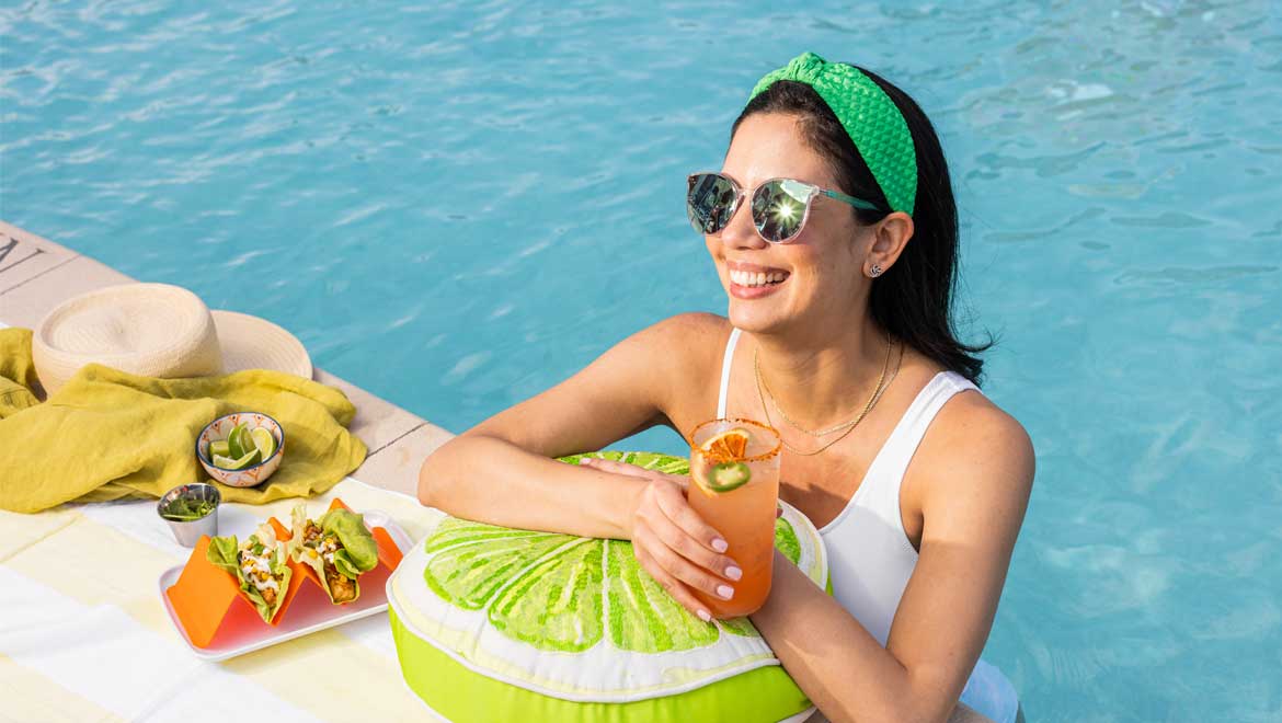 woman enjoying a drink poolside