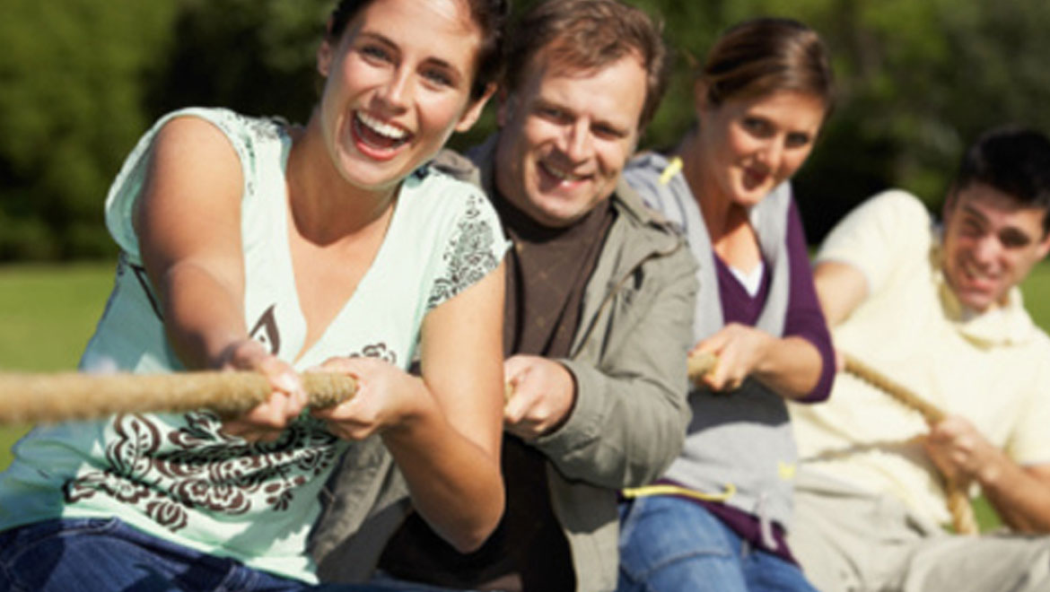 Group of people playing tug of war.