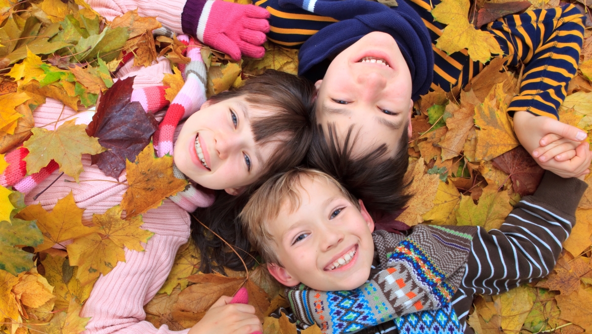 Kids playing in fall leaves