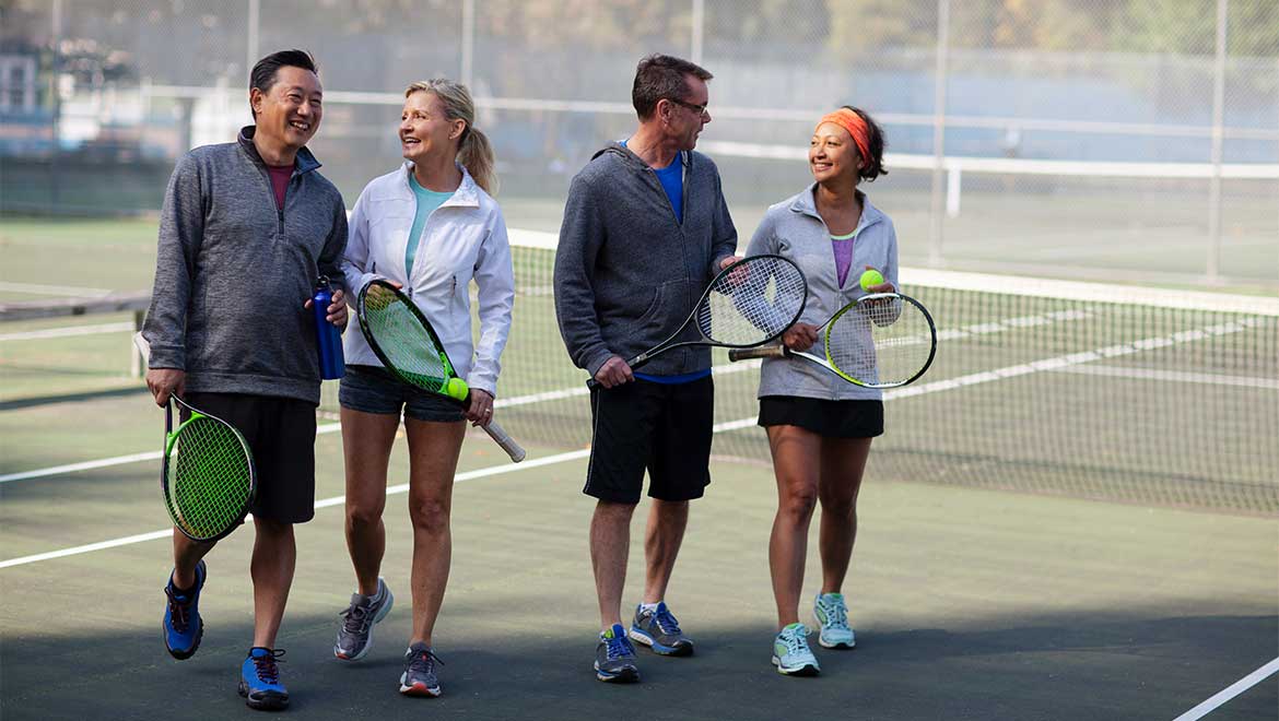 Two couples playing tennis