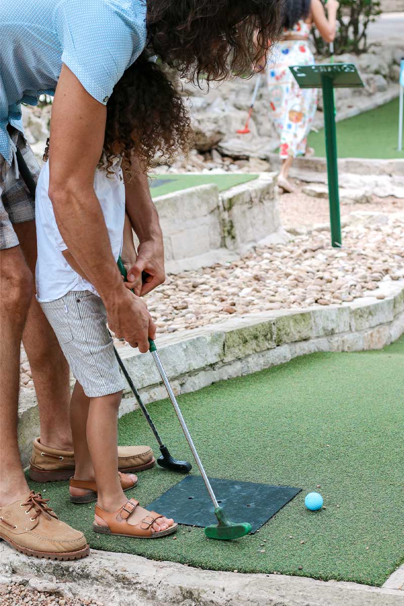 Mom and son playing mini golf