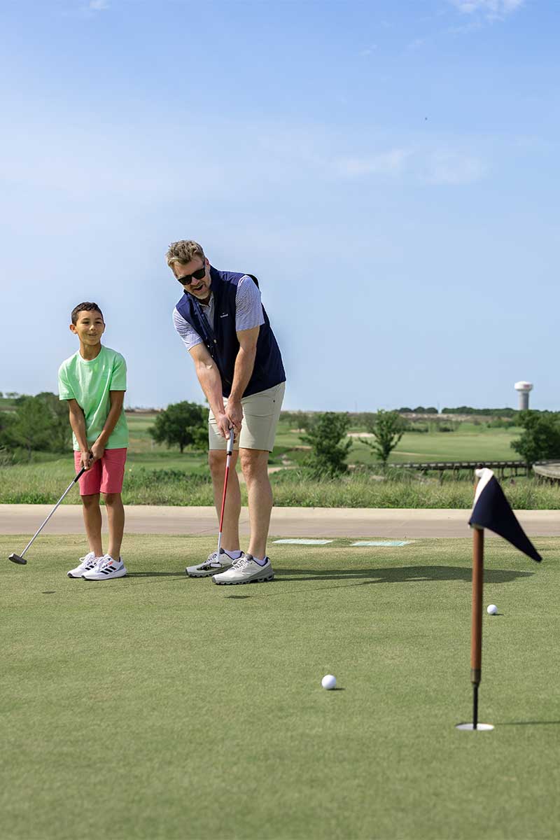 Father and son playing mini golf