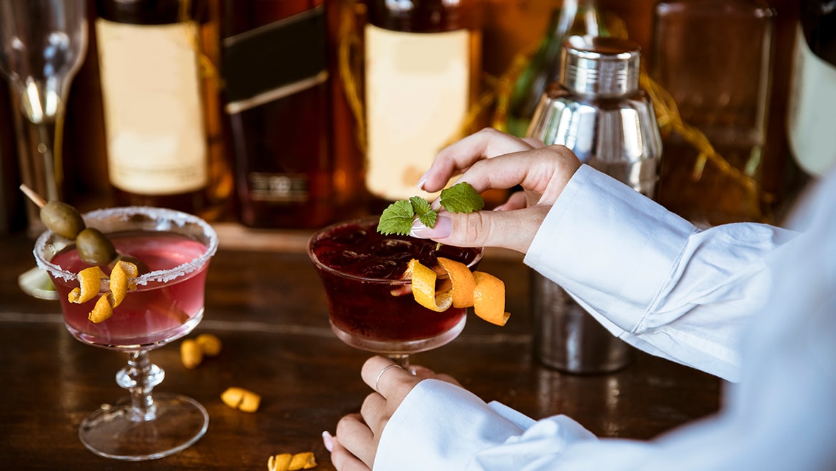 Bartender adding garnish to cocktails