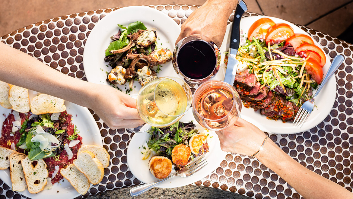 People toasting drinks over food