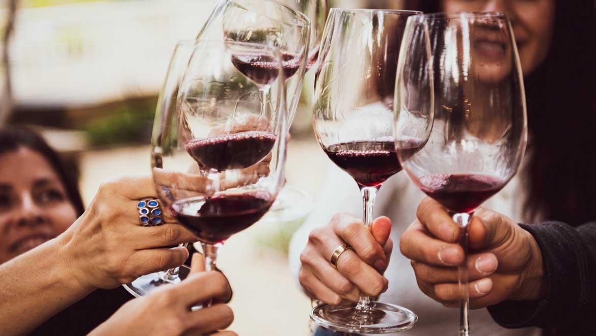 People toasting red wine.