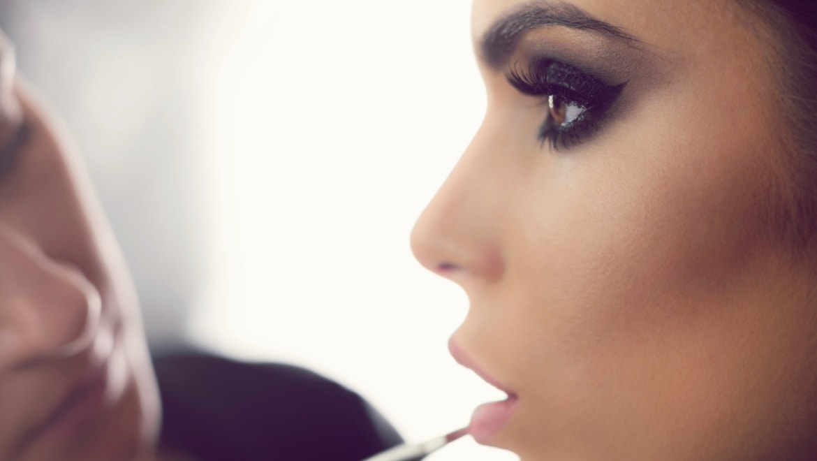 Woman applying lip gloss.