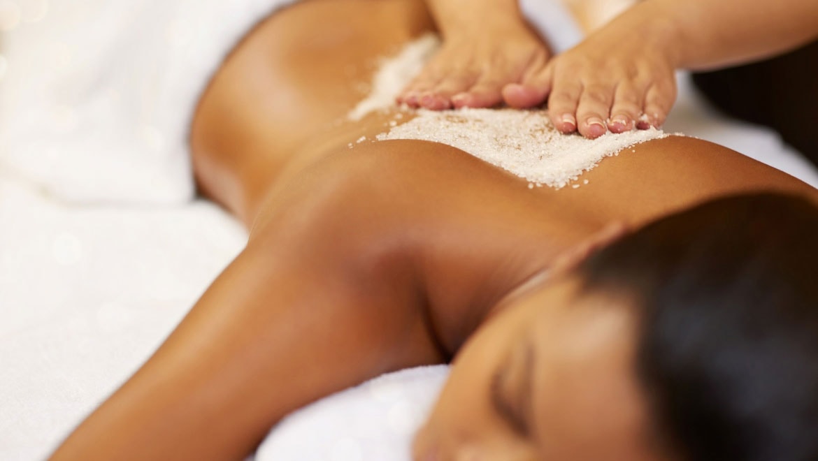 Woman receiving a body scrub treatment.