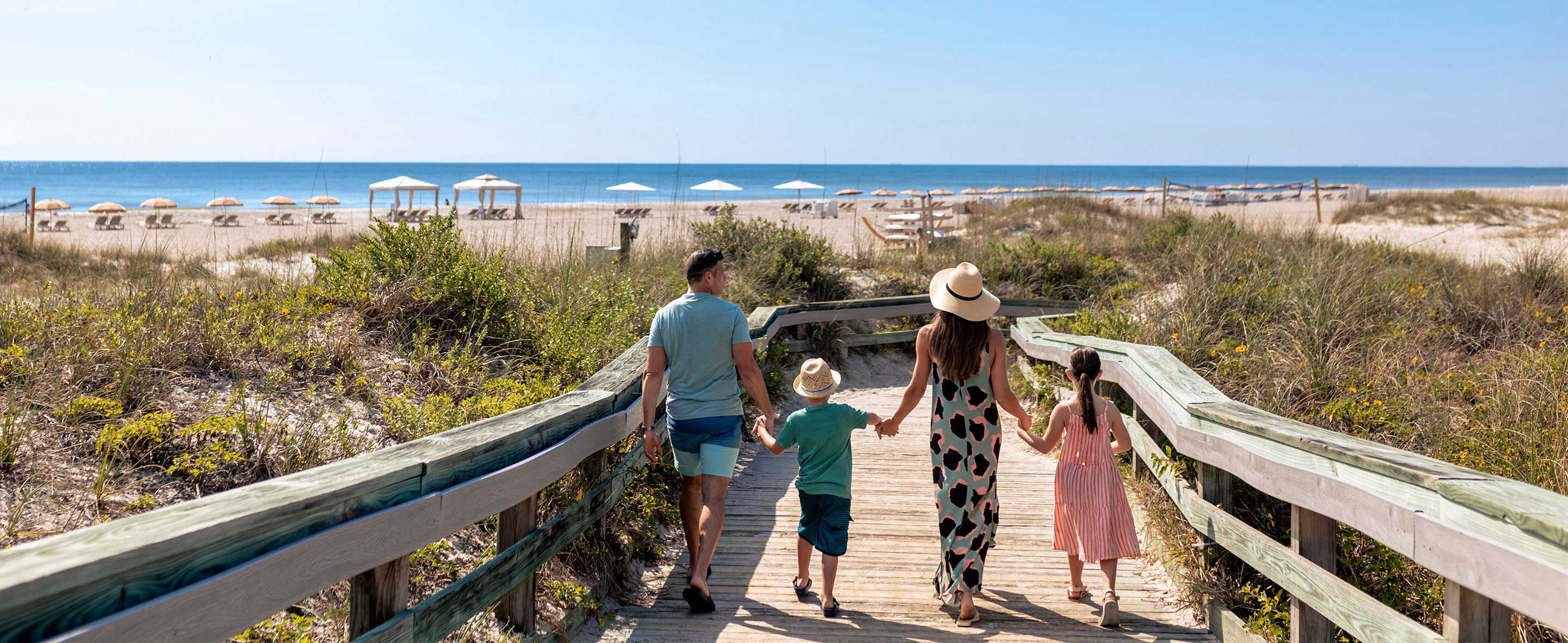Family walking on beach boardwalk