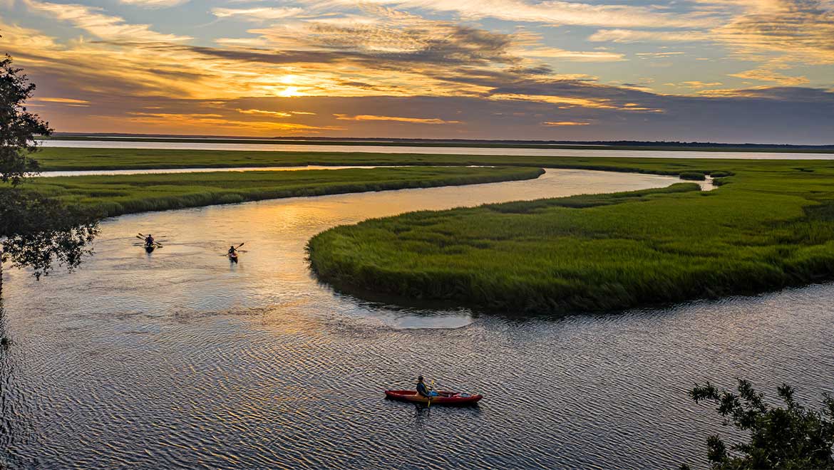 friends kayaking during sunset