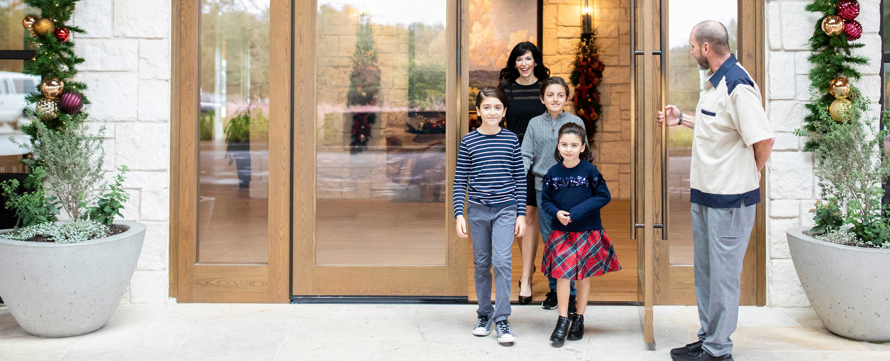 Family exiting the property with holiday decor.