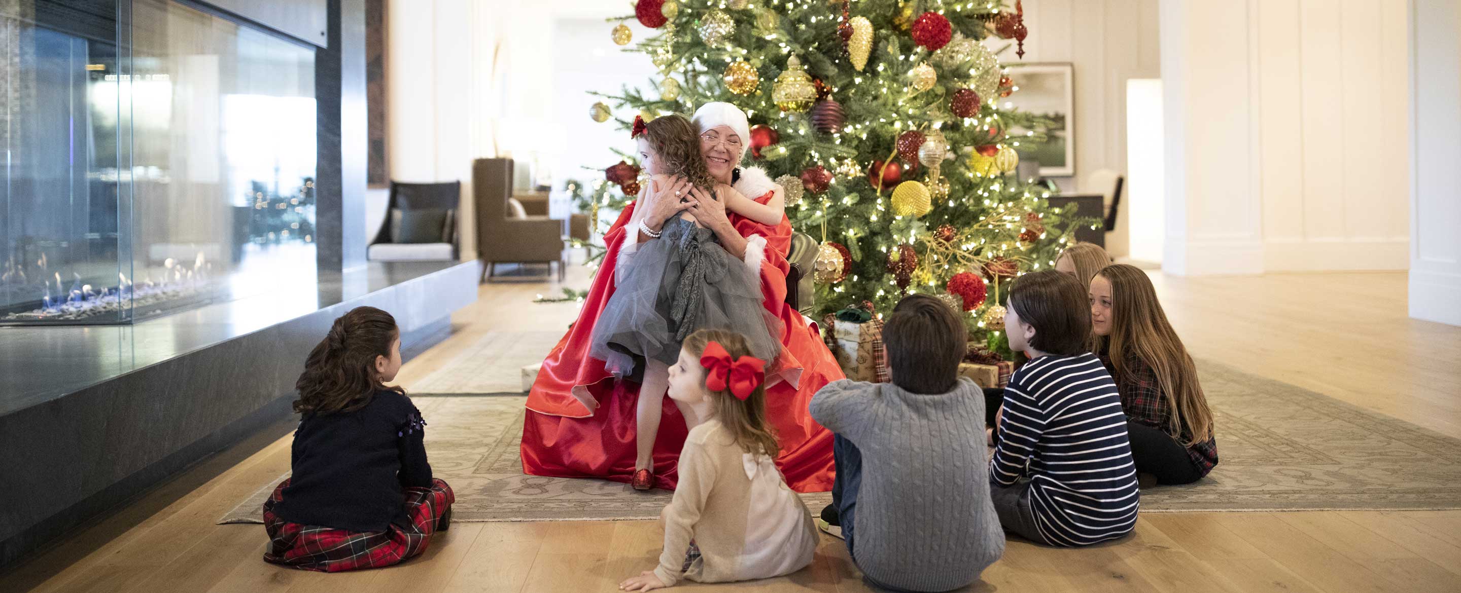 Ms.Clause hugging a child.