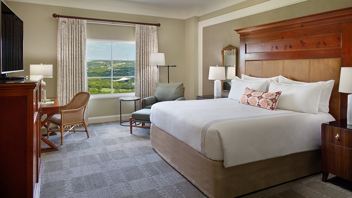 A Premium King Room featuring an activity desk, king bed and lounge chair.