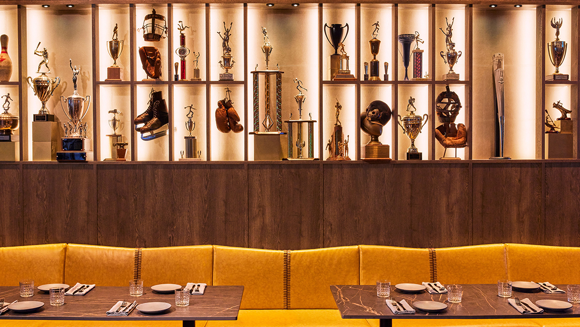  A large trophy installation anchors the Trophy Room inside The Sporting Club, highlighting the camaraderie, culture and excitement of sport - Omni Boston Hotel at the Seaport