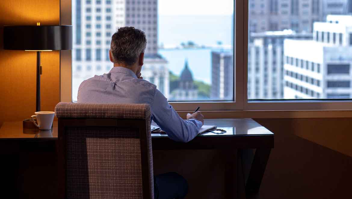 Man working at a desk in his room.