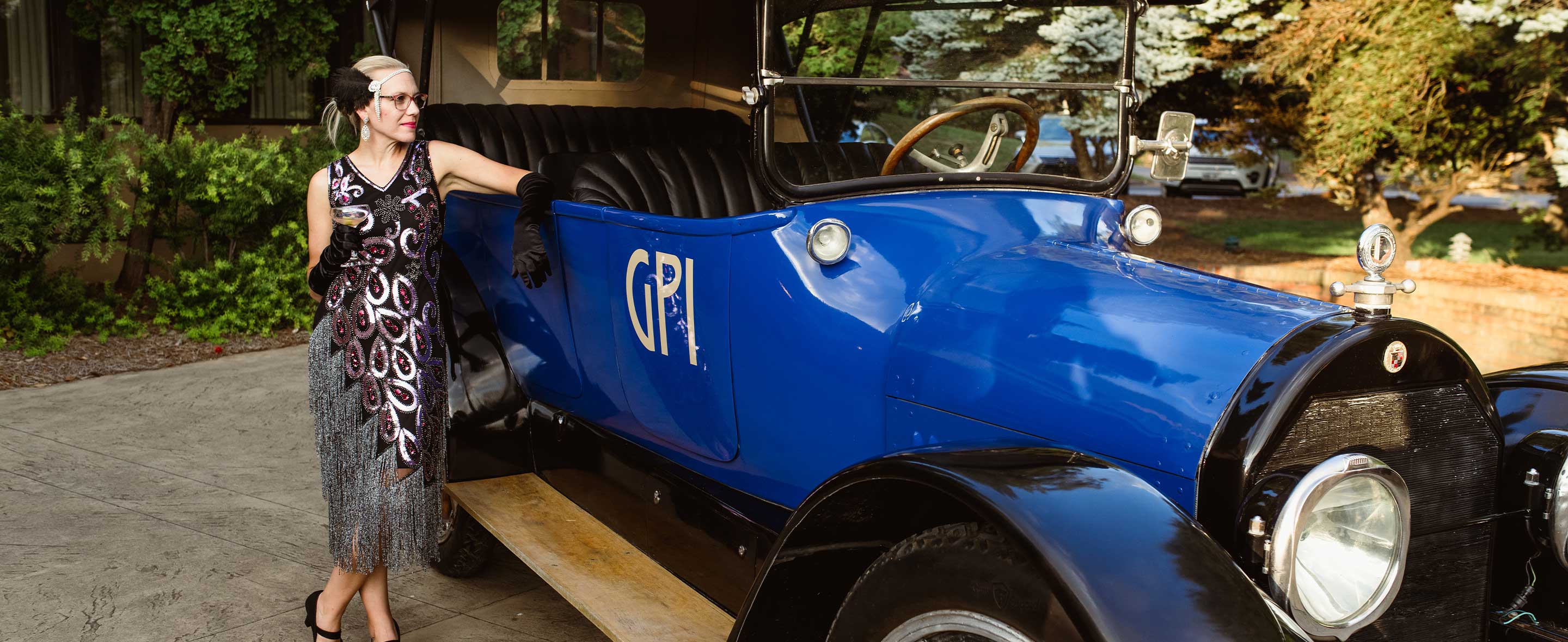 Woman posing next to vintage car