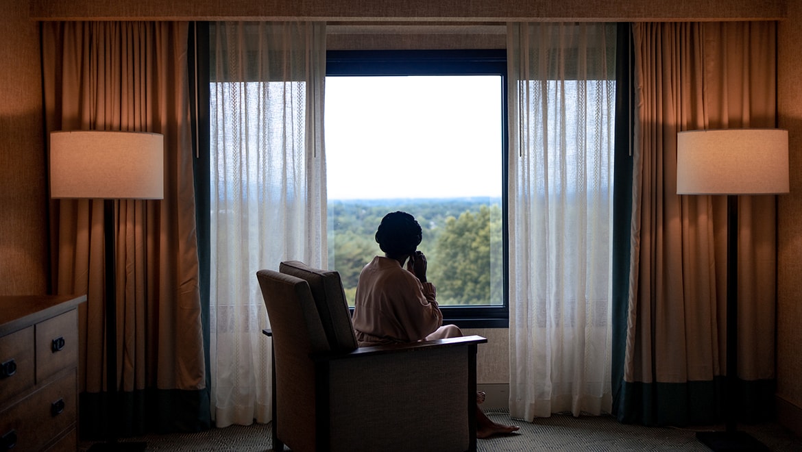 Woman looking at landscape from room.
