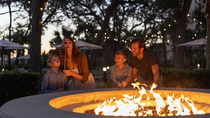 Family making smores by a firepit