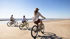 Family riding bikes on the beach