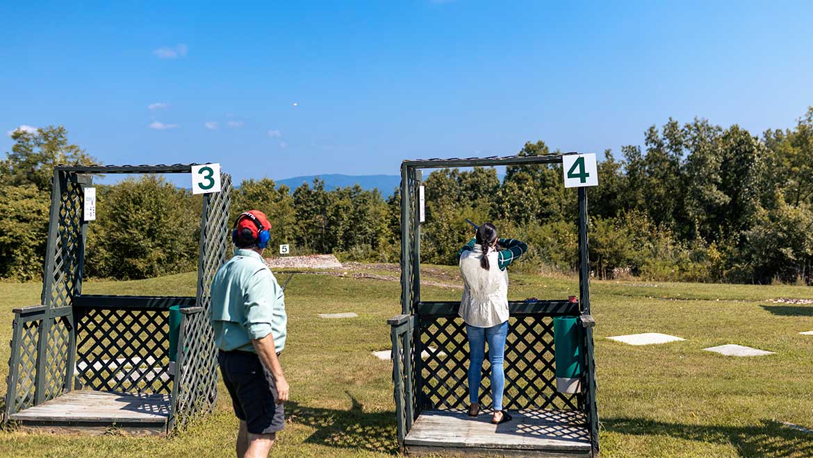 Couple shooting at sporting clay course