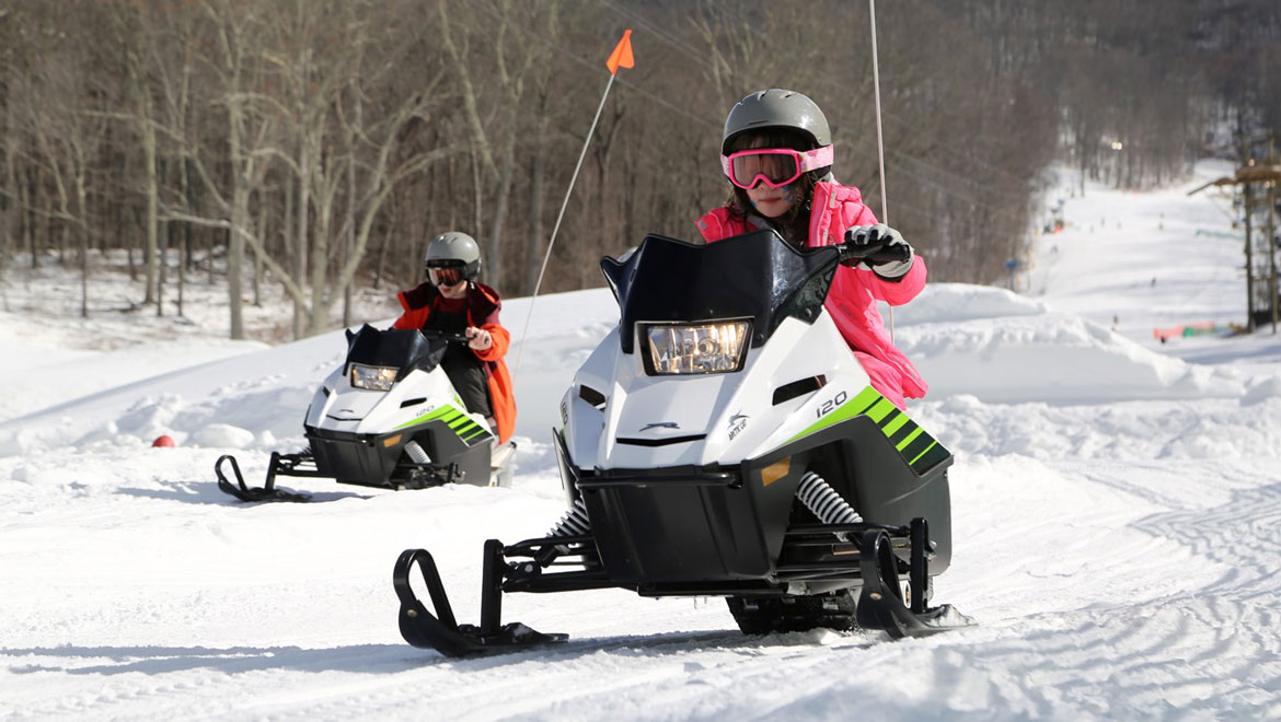People riding snow mobiles