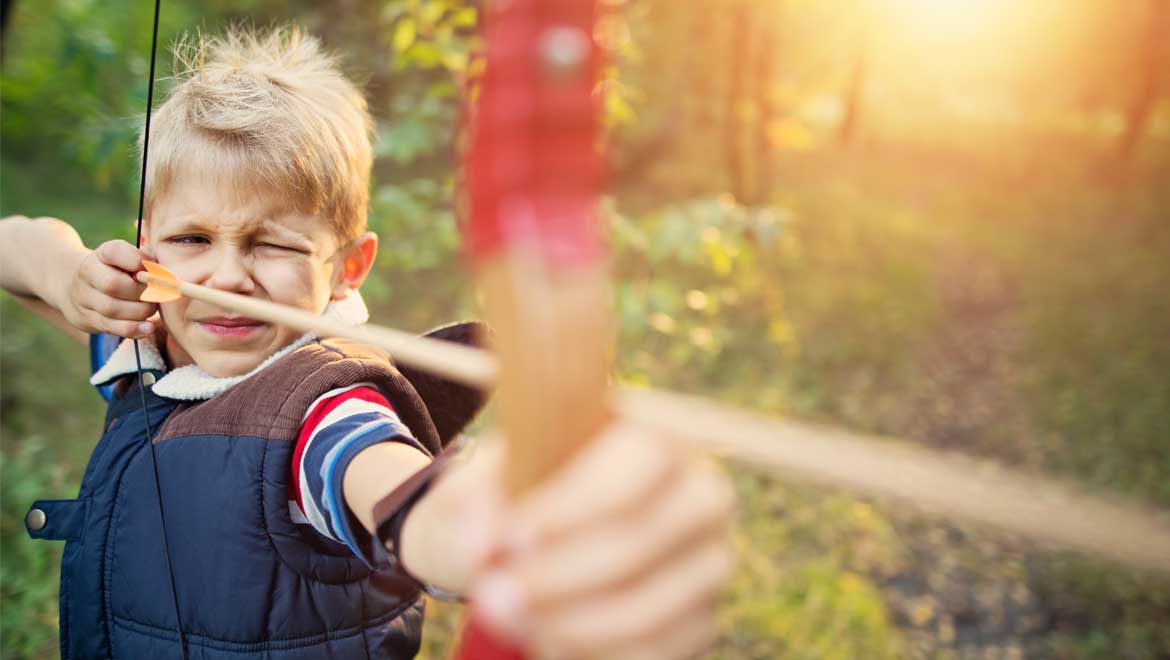 Kid holding an archery bow and arrow