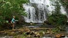 Woman fly fishing near waterfalls.