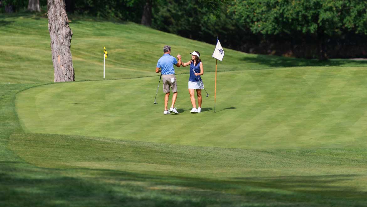 Couple high five on the putting green.