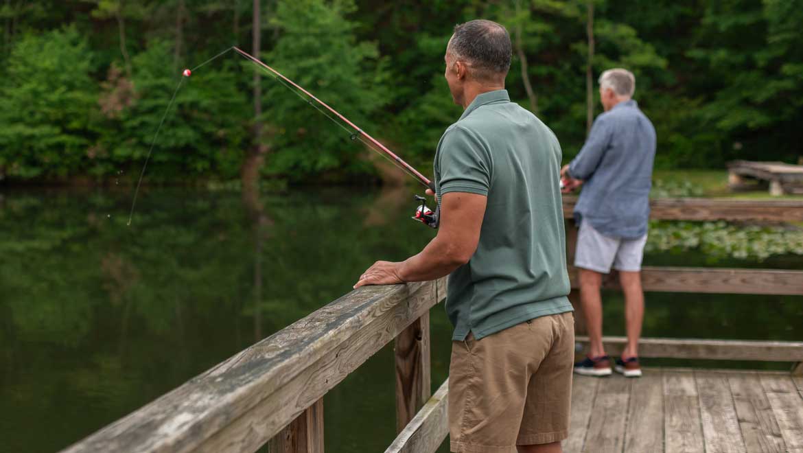 Two men fishing from a dock.