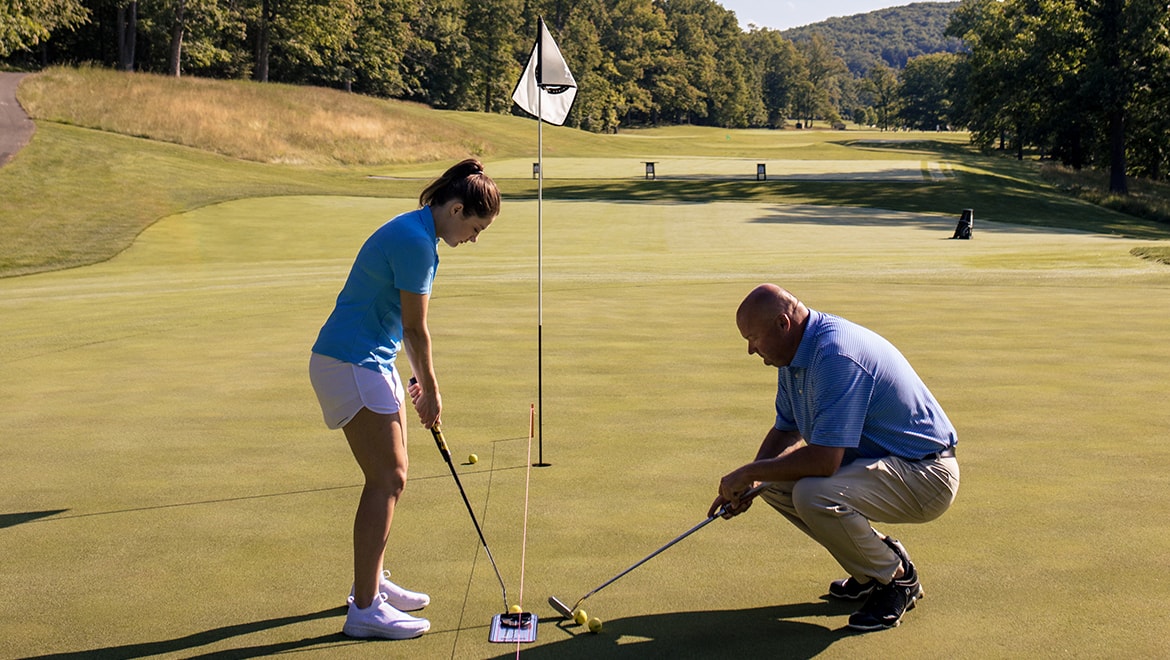 Person receiving a golf lesson.