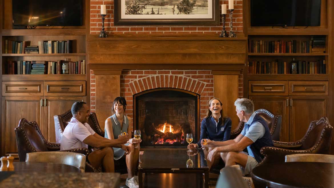 People visiting in front of fireplace.