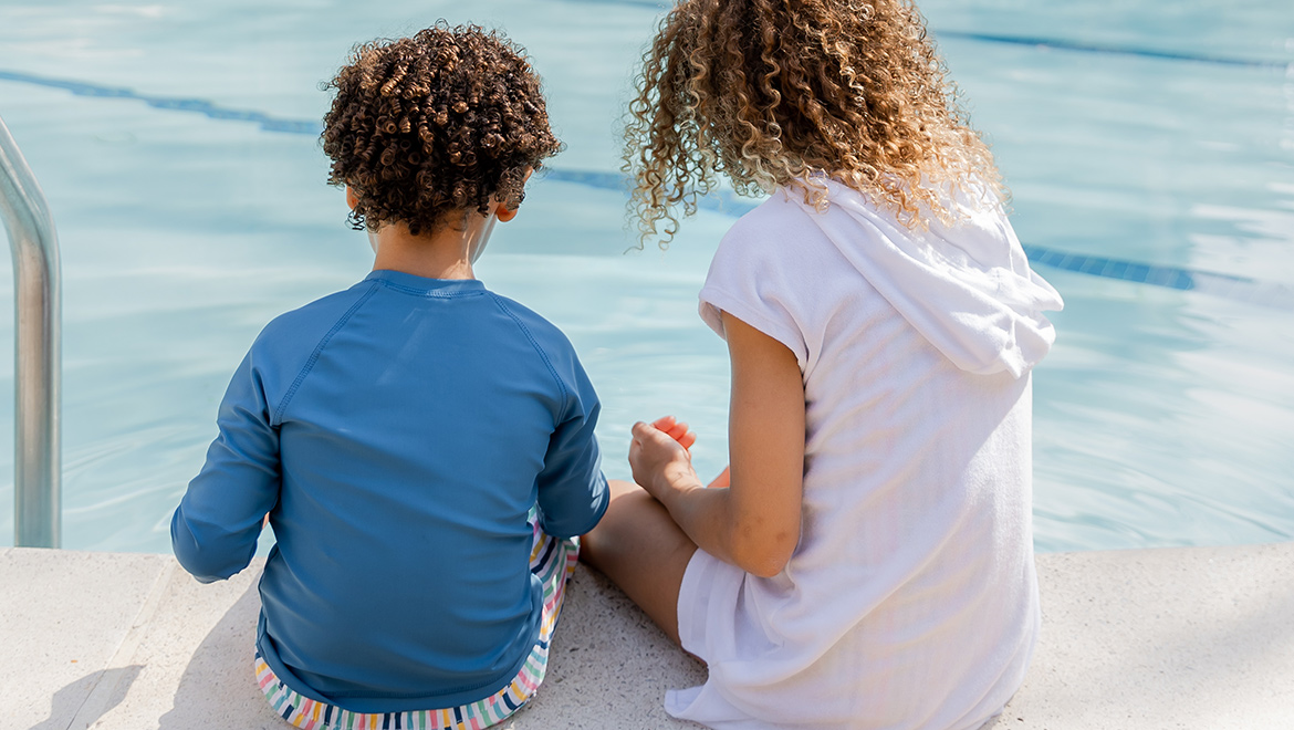 Kids sitting on the edge of the pool